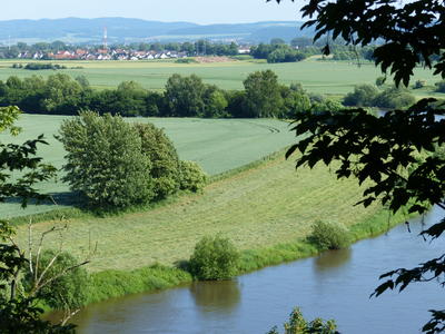 Bild vergrern: Zu sehen ist ein Foto des Landkreises Hameln-Pyrmont auf dem im Vordergrund die Weser zu sehen ist und im Hintergrund Felder, Wiesen und Huser